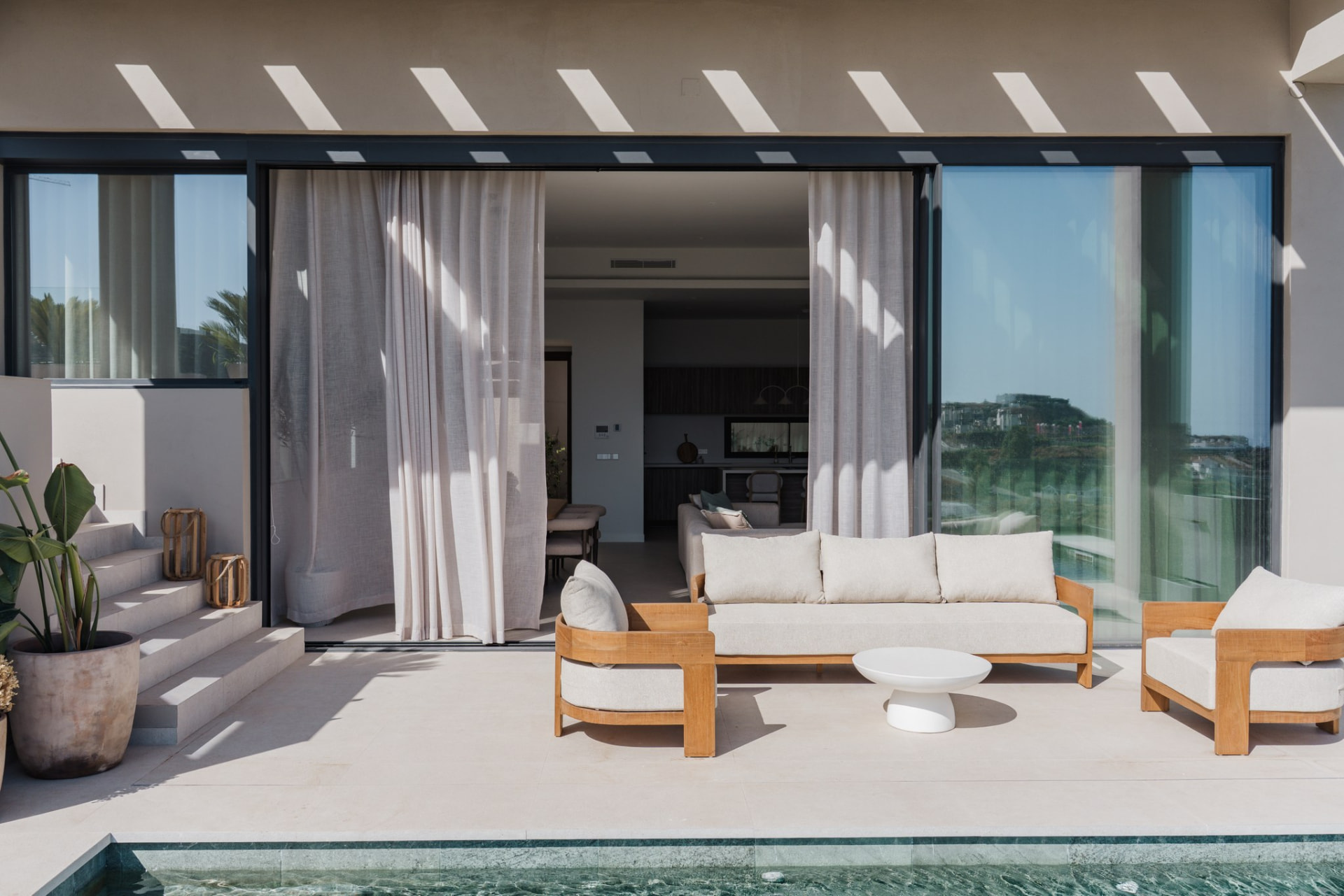 Poolside terrace lounge framed by the pergola